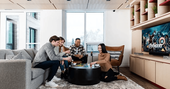 Four people sitting on the floor in a room.